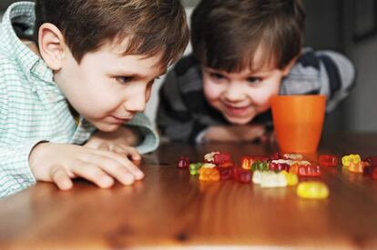 Dos niños mirando con ansía caramelos.