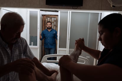 Ernesto Bernal, observa a su padre y a una enfermera mientras le practican cuidado a su hermano.
