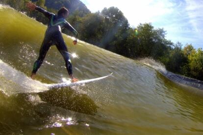 Una persona hace surf sobre olas artificiales.