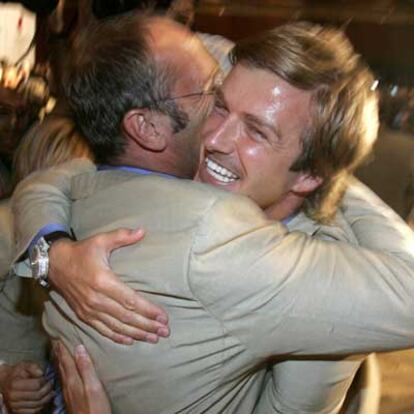 David Beckham y un delegado británico se abrazan entusiasmados.