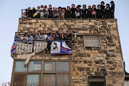 Un grupo de judíos ultraortodoxos subidos a un balcón de un edificio durante una campaña electoral del Yahadut Hathora (Judaísmo de la Torá Unida) en el centro de Jerusalén, un día antes de las elecciones generales israelíes.