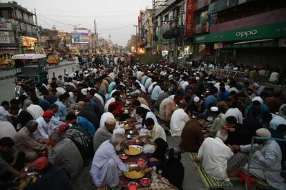 Una multitud de musulmanes pakistaníes comen tras su ayuno durante el primer día del mes sagrado de Ramadán a lo largo de un carretera en Rawalpindi.
