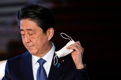 Shinzo Abe, primer ministro japonés, se quita la mascarilla al llegar a la rueda de prensa para anunciar que declarará el estado de alerta sanitaria