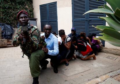 Varias personas son evacuadas de la zona atacada con la ayuda de un soldado keniano durante el atentado a un hotel y un complejo de oficinas en Naironi (Kenia), el 15 de enero de 2019.