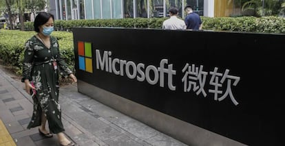 Una mujer pasa junto al logo de Microsoft en las oficinas de la compañía en Pekín. 