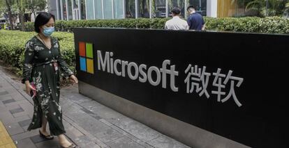 Una mujer pasa junto al logo de Microsoft en las oficinas de la compañía en Pekín.