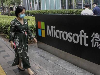 Una mujer pasa junto al logo de Microsoft en las oficinas de la compañía en Pekín. 