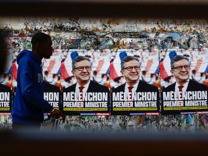 Un hombre pasa frente a los carteles electorales de Jean Luc Mélenchon en París.