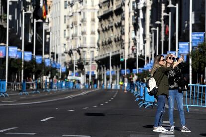 Dos jóvenes en el asfalto de la Gran Vía se hacen un retrato.