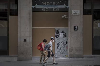 Uns turistes davant d'un hotel tancat al barri Gòtic de Barcelona.