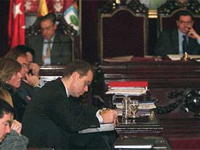 El concejal de Hacienda, Juan Bravo, escucha a la oposición, inclinado sobre sus papeles, durante el pleno de ayer. Al fondo, el alcalde.