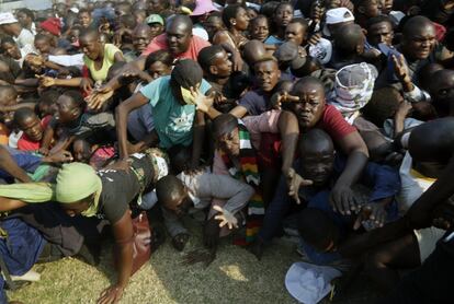 Un grupo de personas se precipitan después de la llegada del ataúd que transportaba al expresidente Robert Mugabe al estadio Rufaro en Harare (Zimbabue).
