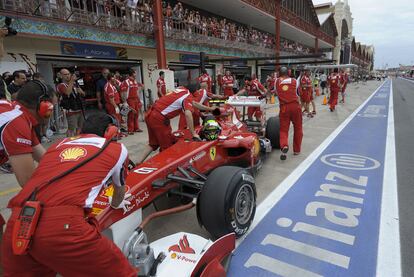 El equipo Ferrari atiende a Felipe Massa a su entrada en boxes.