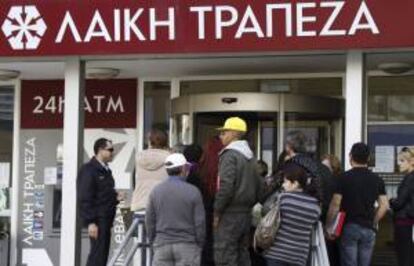 Varias personas hacen cola a las puertas de una sucursal del Banco Laiki en Nicosia (Chipre). EFE/Archivo