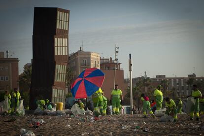 Operarios trabajan en la limpieza de las playas de Barcelona.