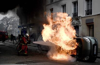 Un bombero apaga las llamas de un vehículo durante las protestas de los 'chalecos amarillos' en París.