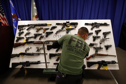 Un agente del FBI exhibe armas incautadas vinculadas a la Mafia Mexicana durante una conferencia de prensa, en Los Ángeles, en febrero de 2019.