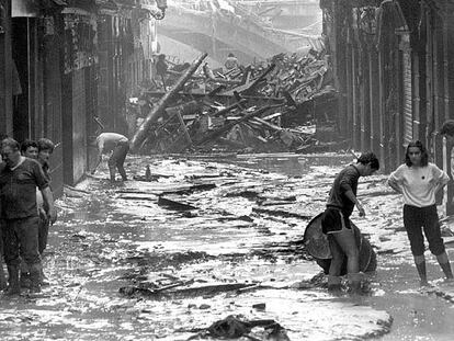 Aspecto que ofrecía la calle Barrenkale Barrena, en el Casco Viejo de Bilbao, tras la riada. Al fondo, el puente de La Ribera, parcialmente destruido.