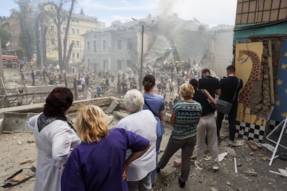 A group of people watch the search for survivors in the rubble of the Ohmatdyt children's hospital, this Monday in kyiv.