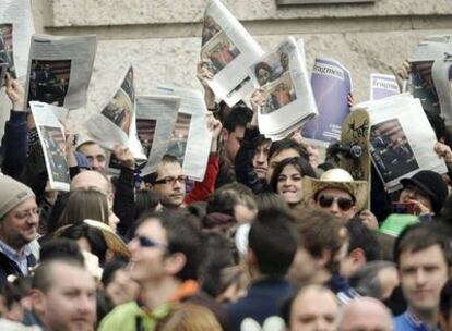 Un grupo de personas exhiben ejemplares de la publicación con las fotos censuradas, ayer, ante el balcón del Ayuntamiento de Valencia.