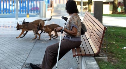 Mónica, una inmigrante guineana sin papeles, sentada en un banco en una calle de Bilbao.