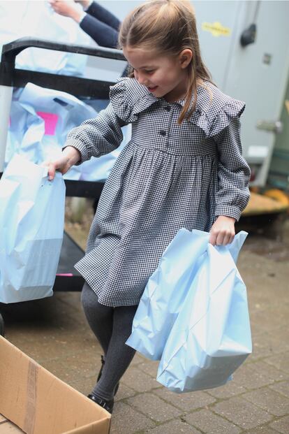 La princesa Carlota de Cambridge, en una foto tomada por su madre con motivo de su quinto cumpleaños (mayo de 2020) en la que se la ve preparando y repartiendo alimentos para los más necesitados a causa de la pandemia del coronavirus.