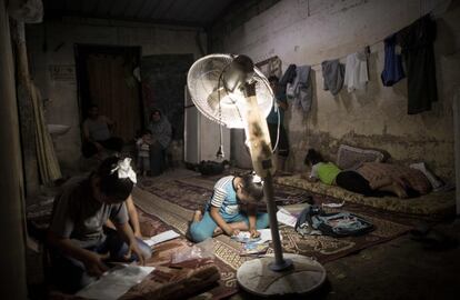 Niños palestinos hacen sus deberes durante un corte de electricidad en Gaza, el 11 de septiembre de 2017.