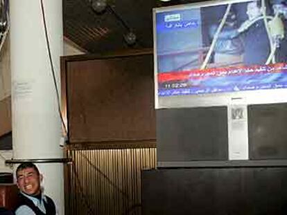 Un grupo de iraquíes sigue en Bagdad la emisión por televisión de la ejecución de Sadam Husein.