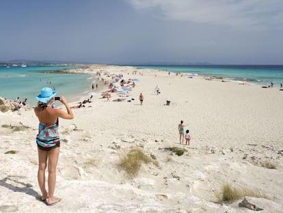 Una mujer fotograf&iacute;a la playa de Ses Illetes, en Formentera (Islas Baleares). 