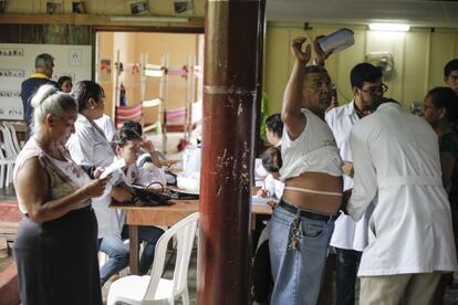 Voluntarios médicos realizando pruebas para determinar si el visitante es propenso a la enfermedad.