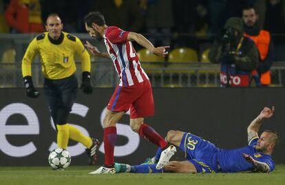 Juanfran (centro) del Atlético de Madrid se hace con la pelota ante la presión de Fedor Kudryashov del FK Rostov.