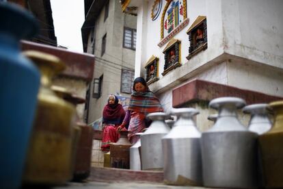 Mujeres nepalíes esperan a llenar sus cántaros de agua en una fuente en el distrito de Lalitpur.