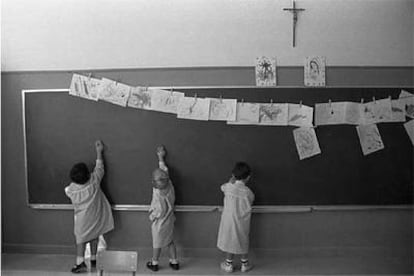 Unos niños dibujan en la pizarra en una clase de un colegio religioso.