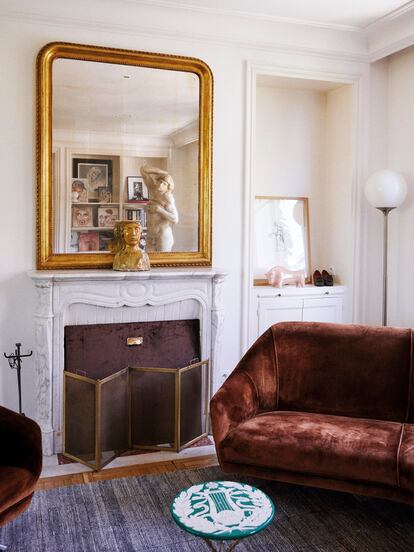 El salón, con espejo del siglo XIX, figura de cerámica de los años sesenta, sofá de Osvaldo Borsani de los sesenta y mesa de Fornasetti de los cincuenta. 