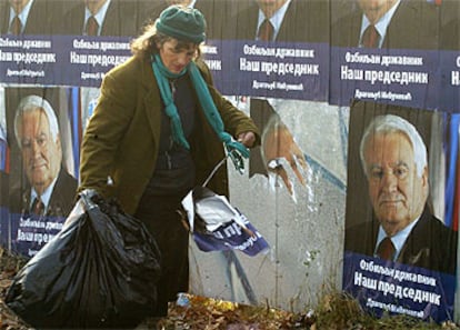 Un trabajador recoge restos de propaganda electoral del candidato Dragoljub Micunovic.