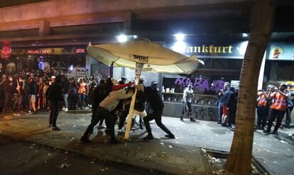 Protesters take down a restaurant umbrella to use for a barricade during Saturday’s protest.