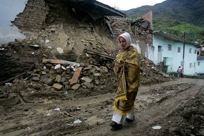 Una mujer camina frente a una casa que resultó dañada por un terremoto en Quetame, al sureste de Bogotá, el 25 de mayo de 2008.