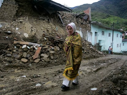 Una mujer camina frente a una casa que resultó dañada por un terremoto en Quetame, al sureste de Bogotá, el 25 de mayo de 2008.