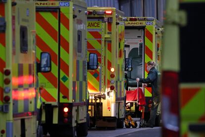 Una trabajadora baja a un paciente de una ambulancia junto al hospital Royal London, este martes. 