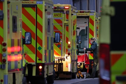 Una trabajadora baja a un paciente de una ambulancia junto al hospital Royal London, este martes.