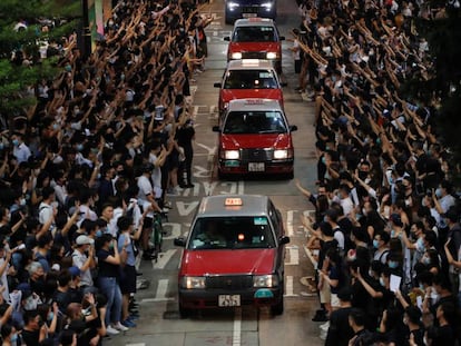 Manifestantes abrem espaço para táxis em Hong Kong durante um protesto em solidariedade ao estudante baleado pela polícia durante os distúrbios de 1º de outubro.
