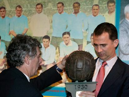 El príncipe Felipe sostiene un balón que se utilizó en el primer mundial celebrado en Uruguay en 1930 ante Ángel María Villar.