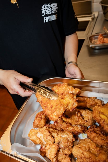 'El Puto Ken' sostiene una pieza de pollo en su nuevo local Fry House en Barcelona.