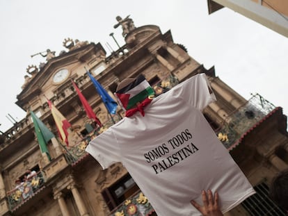 Una persona sujeta una camiseta en la que se lee 'Somos todos Palestina' antes del Chupinazo de San Fermín 2025, en la plaza del Ayuntamiento de Pamplona.