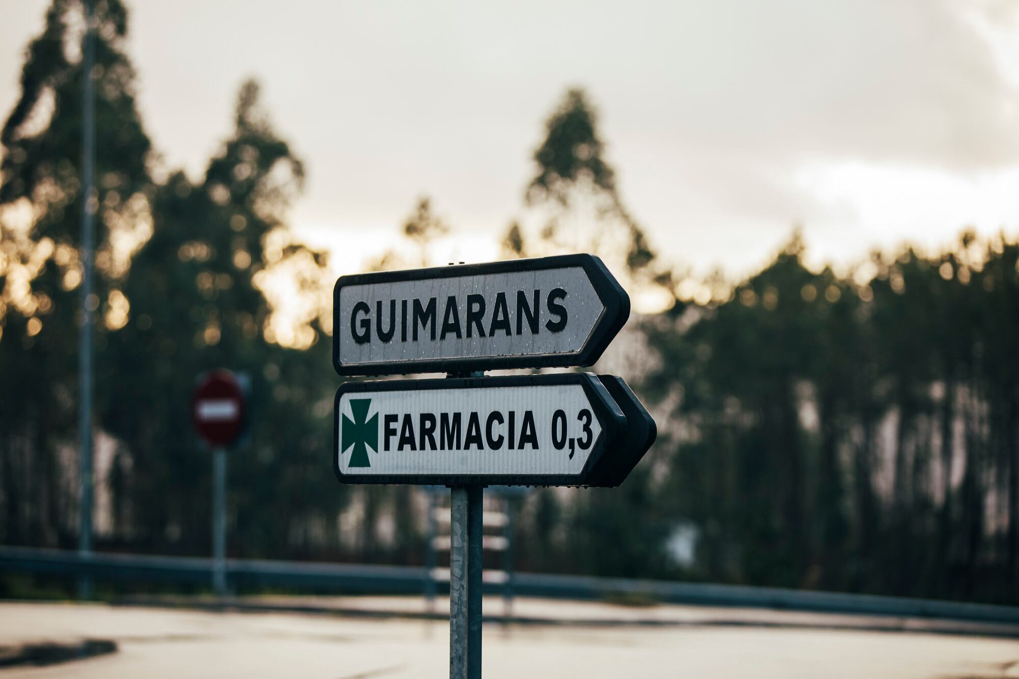 Señalización vial indicando la localización de una farmacia en una zona rural de Ames (A Coruña).