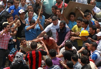 Manifestantes contra el Ejército golpean a un hombre acusado de agredirles, durante la batalla campal en el barrio de Abasiya, El Cairo.