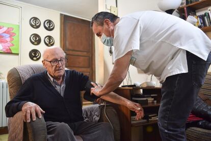 Guillermo Bernués le toma la tensión a Julio Rivera en su casa de Saravillo (Huesca).