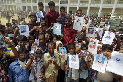 Familiares de desaparecidos en el derrumbe del edificio en Savar, Dacca, muestran sus retratos, 26 de abril de 2013.
