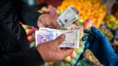 Un comprador paga por productos agrícolas en un mercado de alimentos en Bogotá, Colombia.