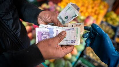 Un comprador paga por productos agrícolas en un mercado de alimentos en Bogotá, Colombia, en una imagen de marzo de 2023.